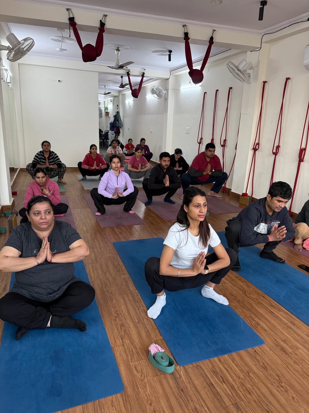 Group meditation and breathing session with students seated on mats at Veda Yoga Studio
